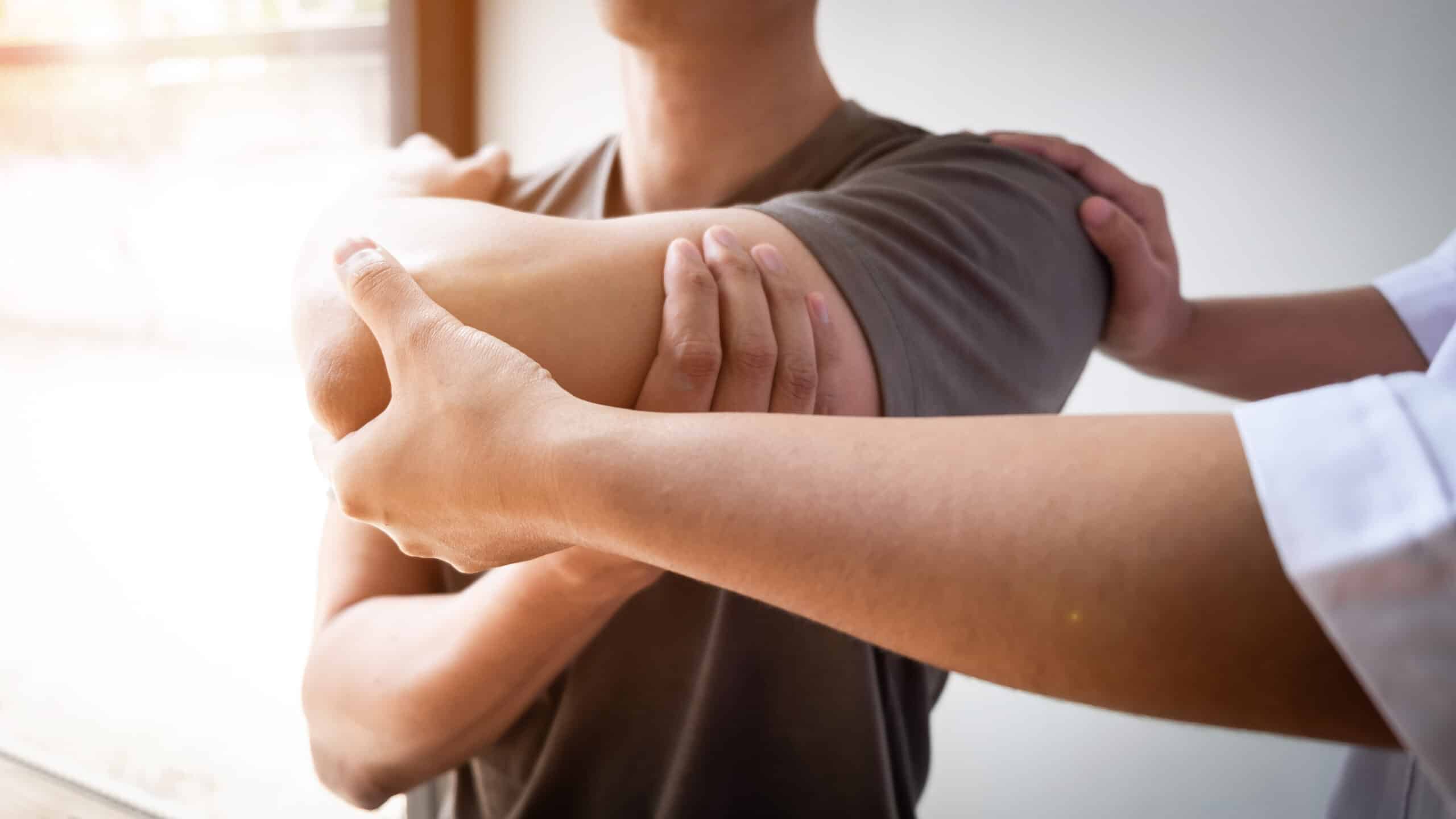 Therapist Treating A Male Injured By Rotator Cuff Stretching Met Therapist Treating A Male Injured By Rotator Cuff Stretching Met